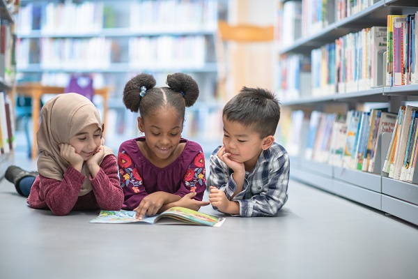 Children reading on the floor of a library